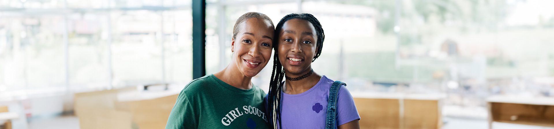  A volunteer and Girl Scout smiling at the camera 